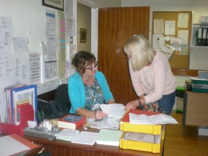 Volunteer Receptionist Maria Hynes discussing a message with Community Clinical Nurse Specialist Jane Coles